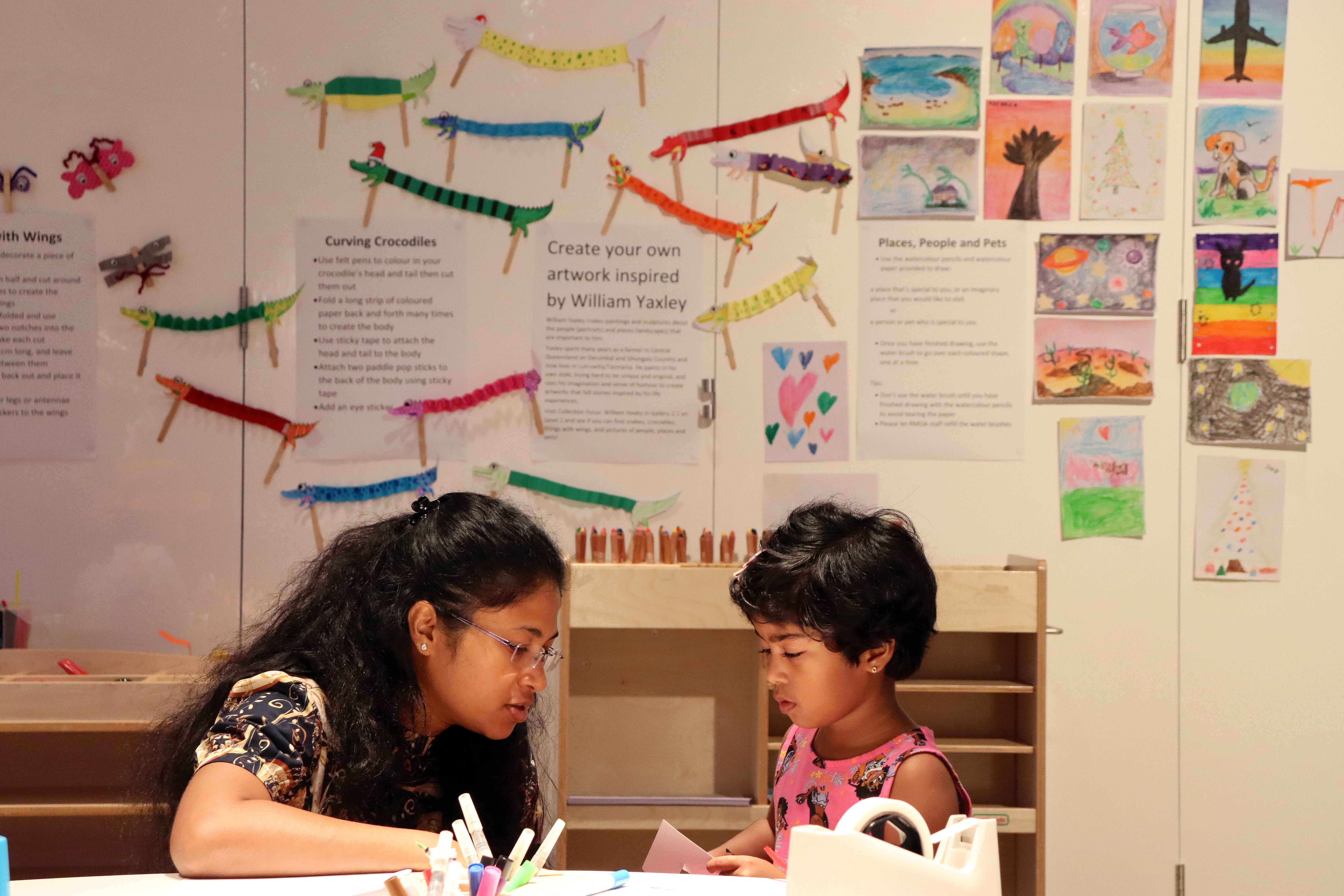 A child and mother creating artwork together in RMOA school holiday activities.