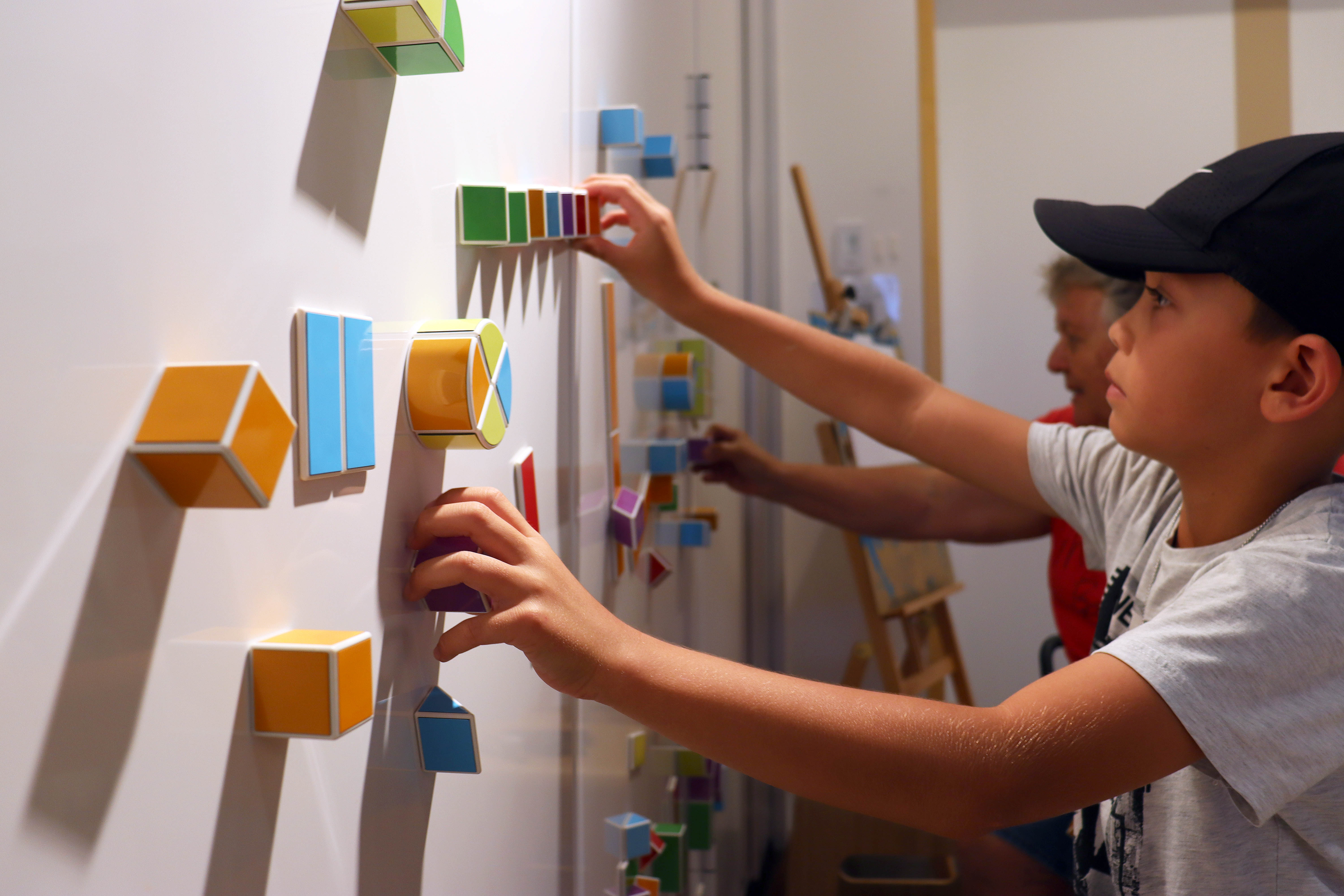 A child and grandmother playing with magnetic blocks at RMOA school holiday activities.